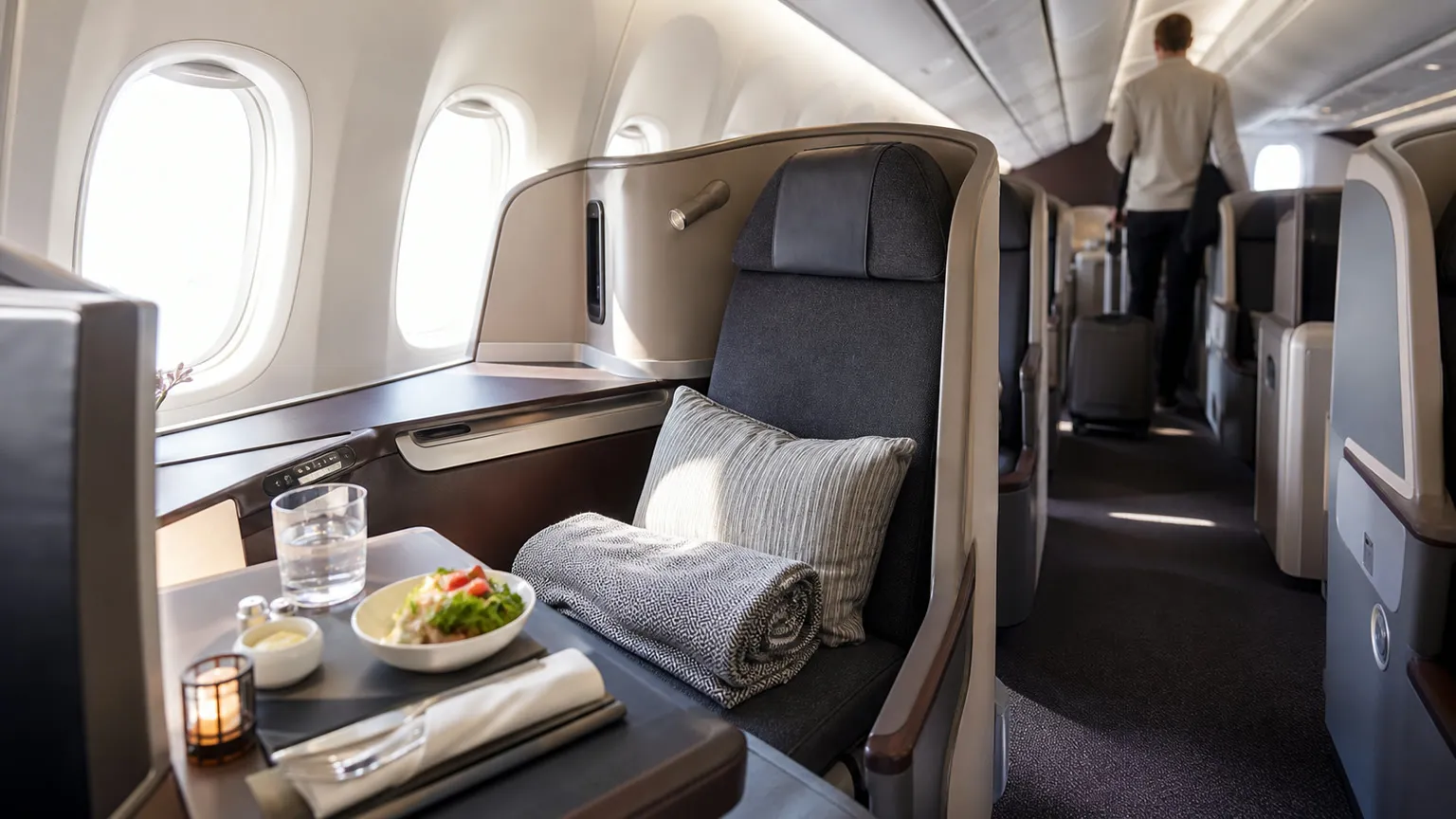 Premium business class-kabine i et moderne fly med dagslys gennem vinduerne og et klargjort sæde i forgrunden