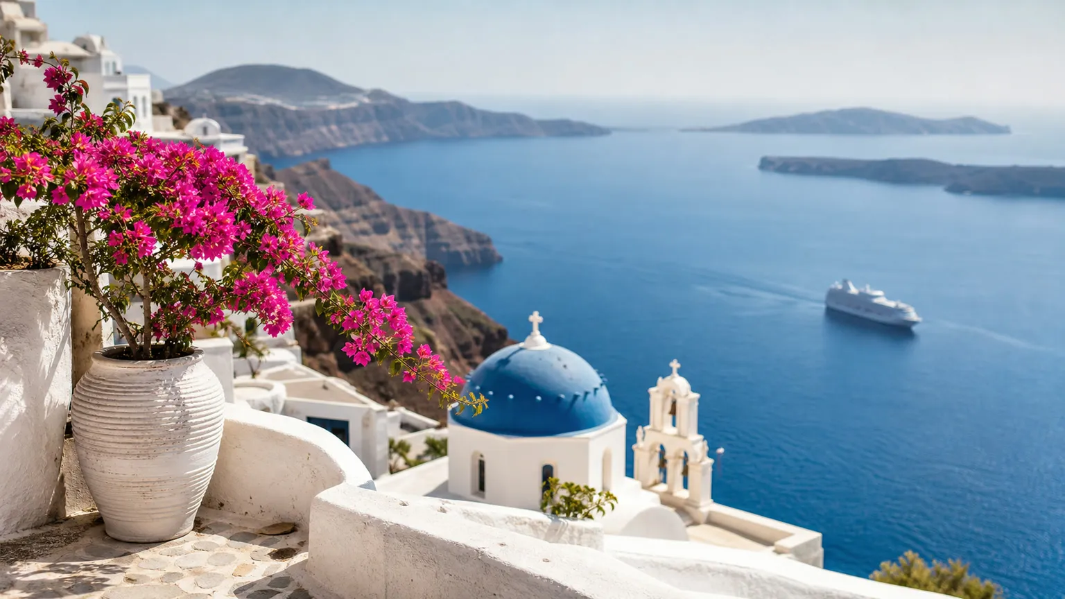 Hvid terrasse på Santorini med bougainvillea, blå kuppel, calderaudsigt og færge på Det Ægæiske Hav