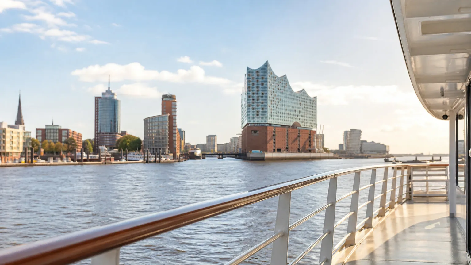 Færgedæk på Elben med udsigt mod Elbphilharmonien og Hamborgs havn i sollys