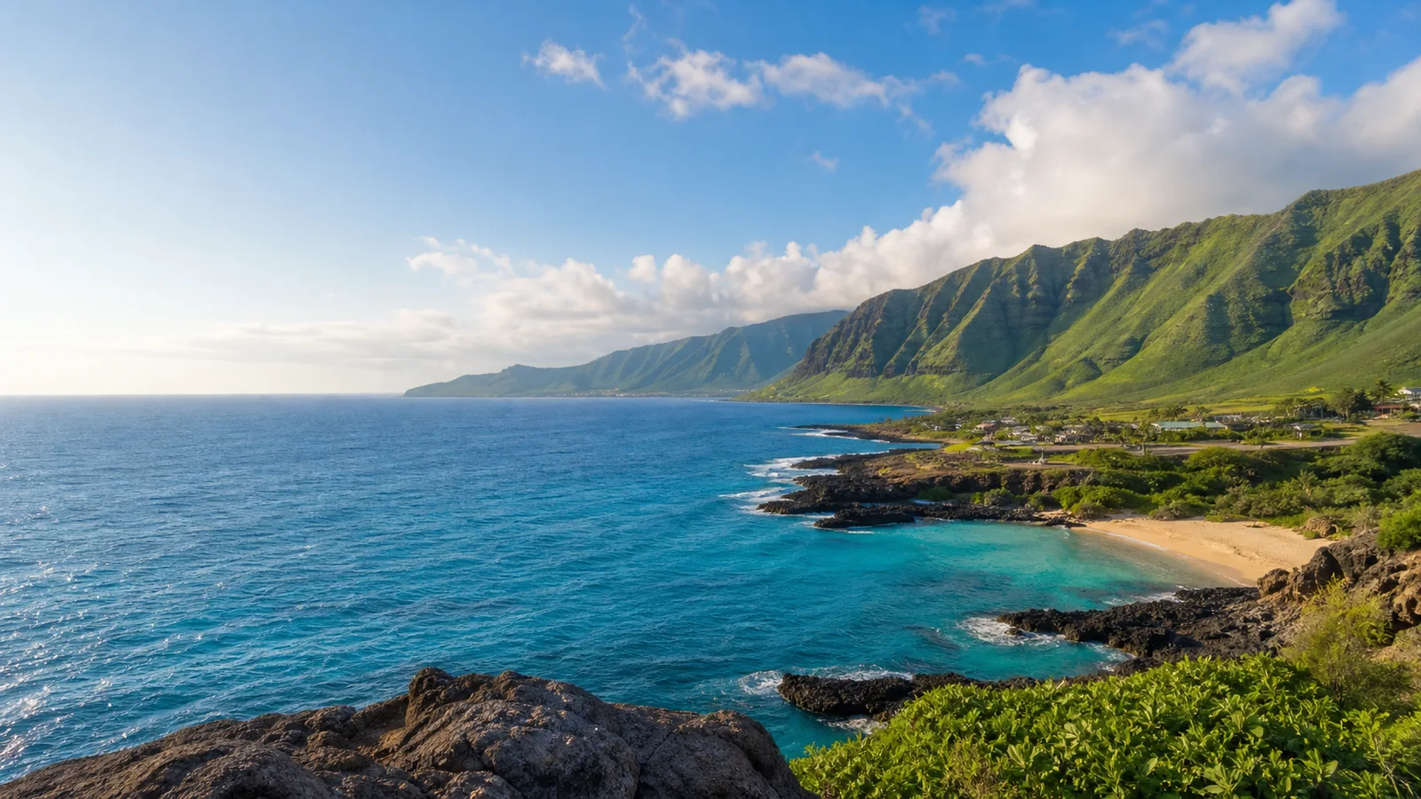 Tropisk kyststrækning på Hawaii med vulkanske bjerge, grønne dale og turkisblåt Stillehav
