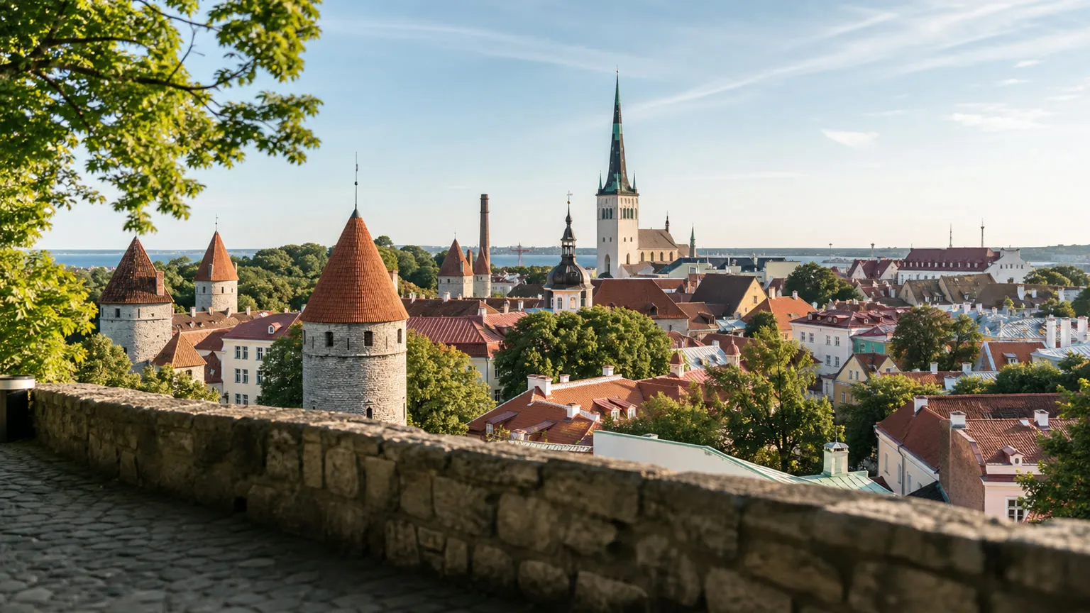 Udsigt fra Toompea over Tallinns gamle bydel med røde tegltage, middelaldertårne og kirkespir i morgensol