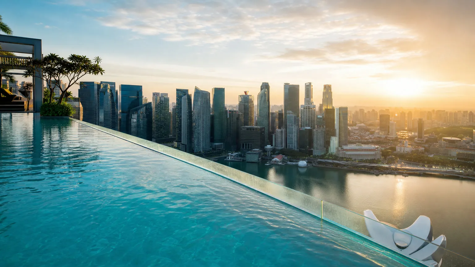 Tagterrasse infinity pool i gyldent morgenlys med turkis vand og udsigt over moderne skyline og bugt